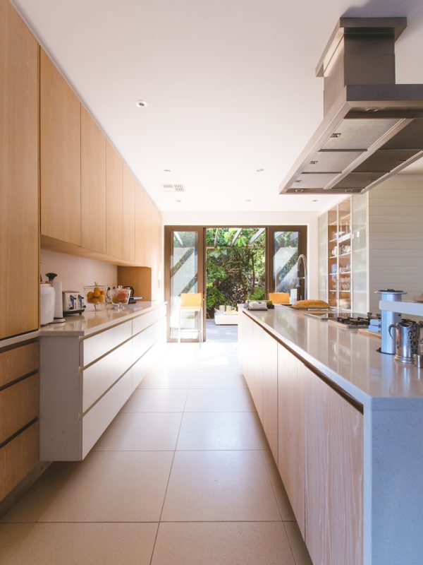 white wooden kitchen island and cupboard cabinets near glass panel door